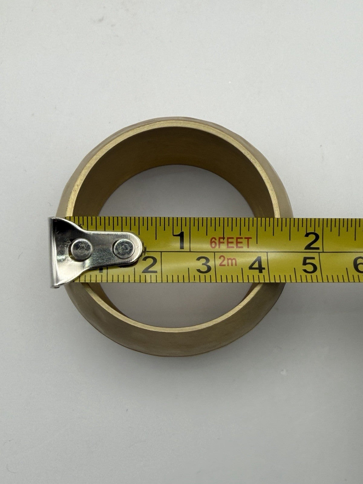 vintage or late 20th-century hammered brass napkin rings, often sold in sets.
