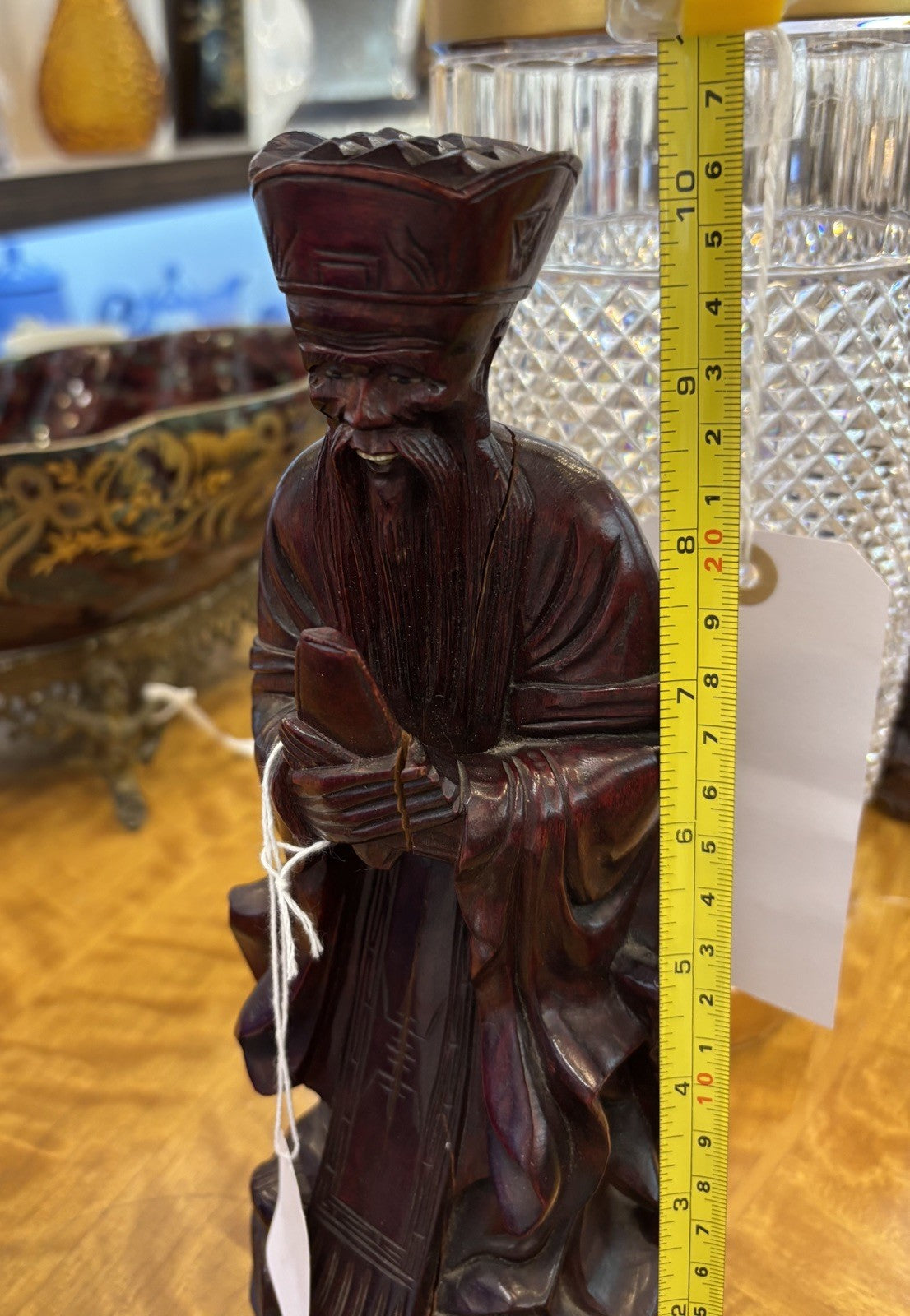 The statue is a carved wooden figurine of the Chinese deity Wenchang Wang.