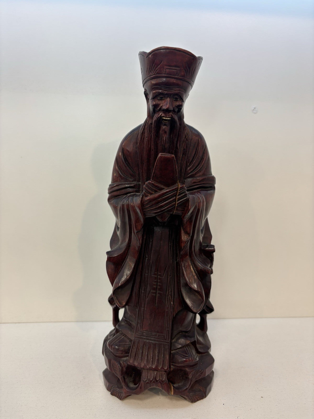 The statue is a carved wooden figurine of the Chinese deity Wenchang Wang.