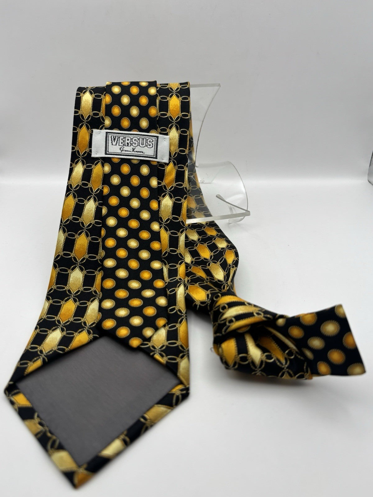 Gianni Versace necktie features a vibrant black and gold geometric chain pattern