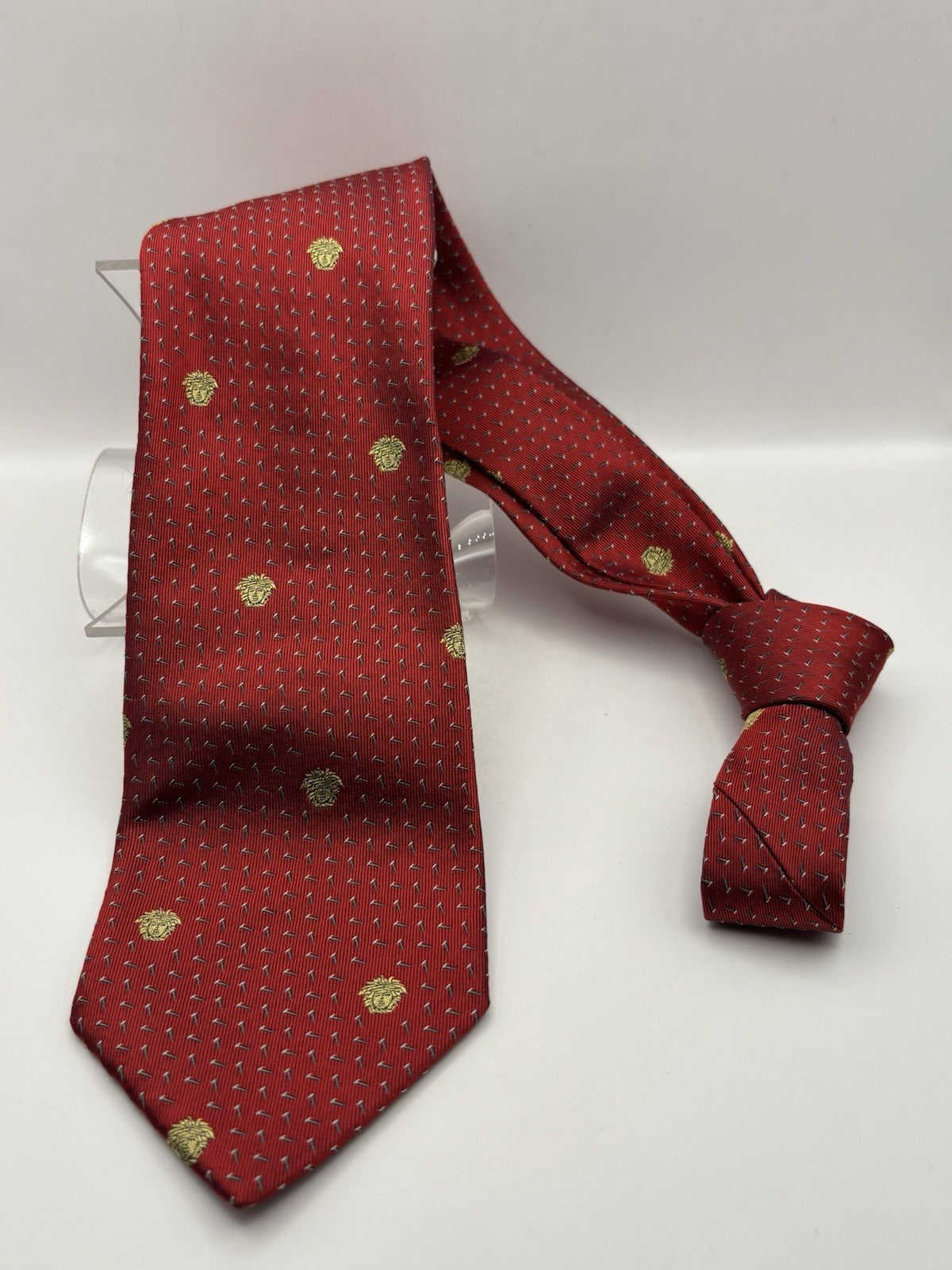 Vintage Gianni Versace red silk tie featuring a golden Medusa head pattern.