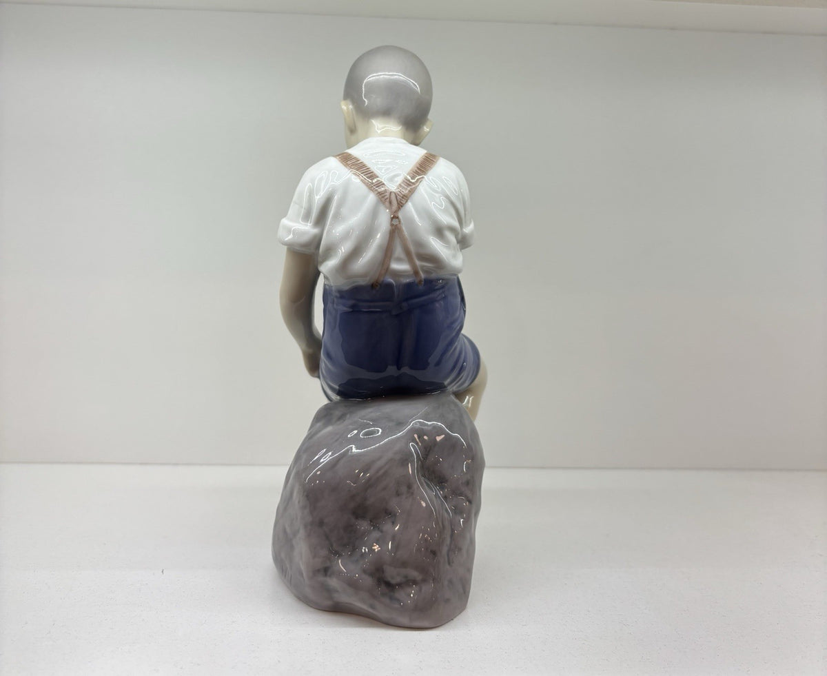 Bing & Grondahl Boy sitting on stone rolling up trousers
