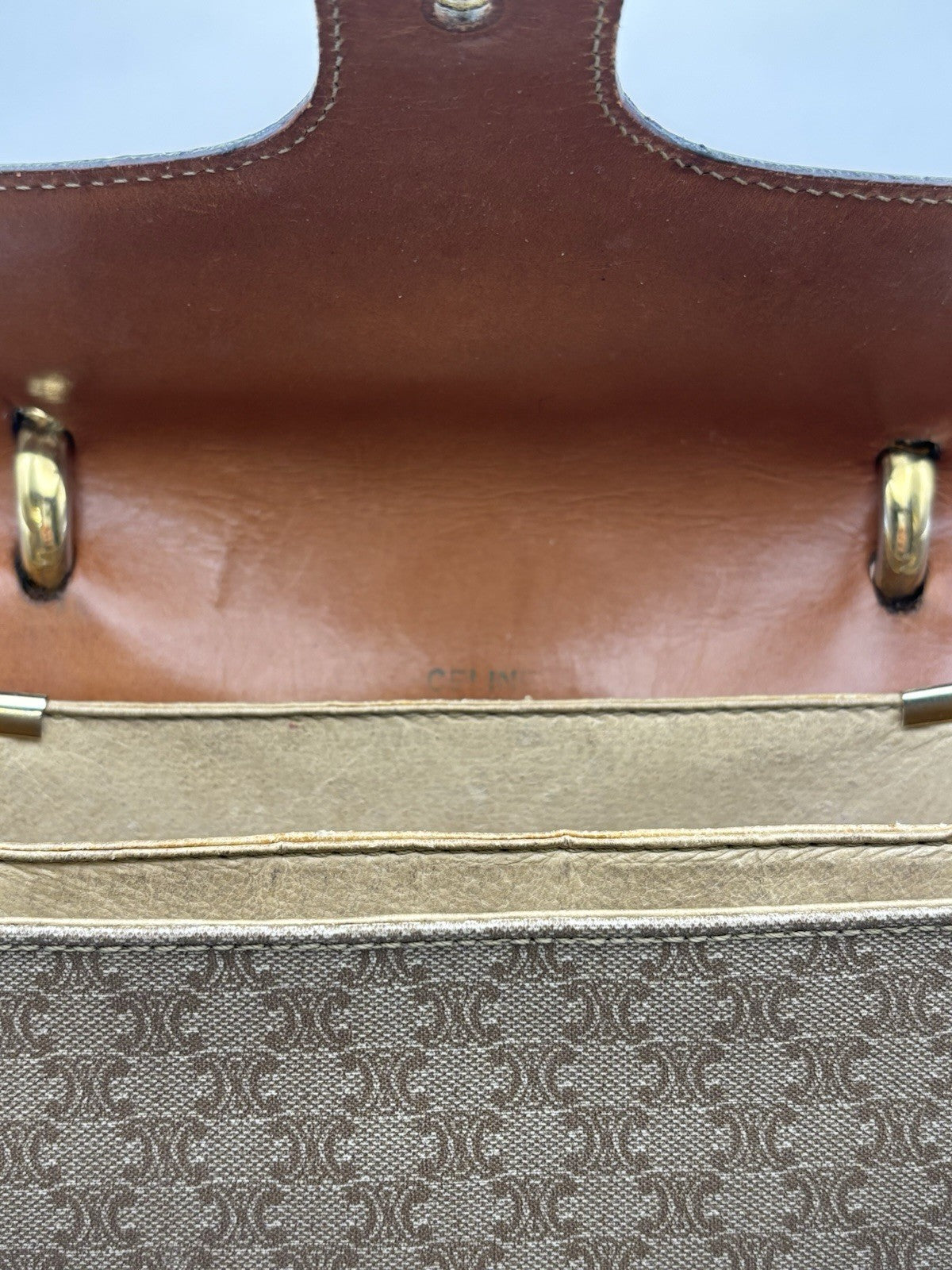 Celine Macadam leather top handle bag with a horse carriage logo buckle.