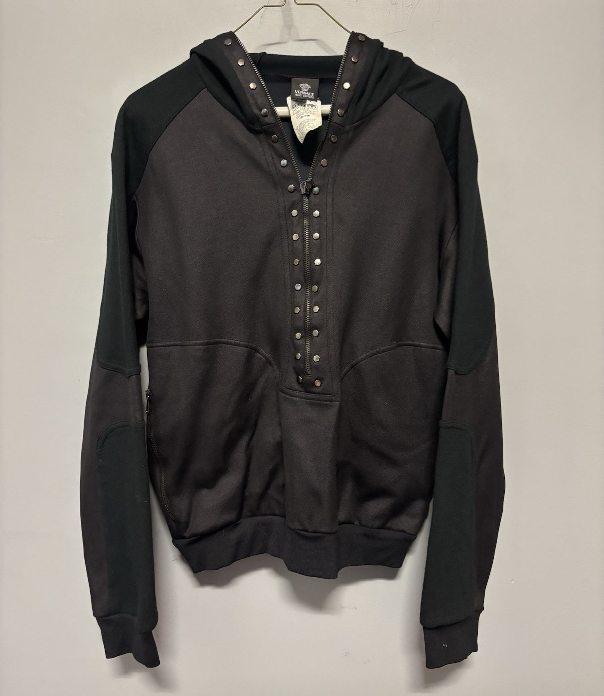 Black Versace hoodie with a half-zip and stud details.