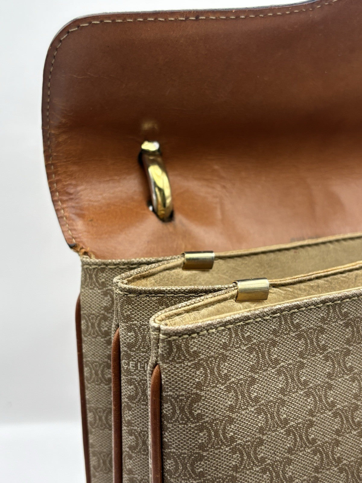 Celine Macadam leather top handle bag with a horse carriage logo buckle.