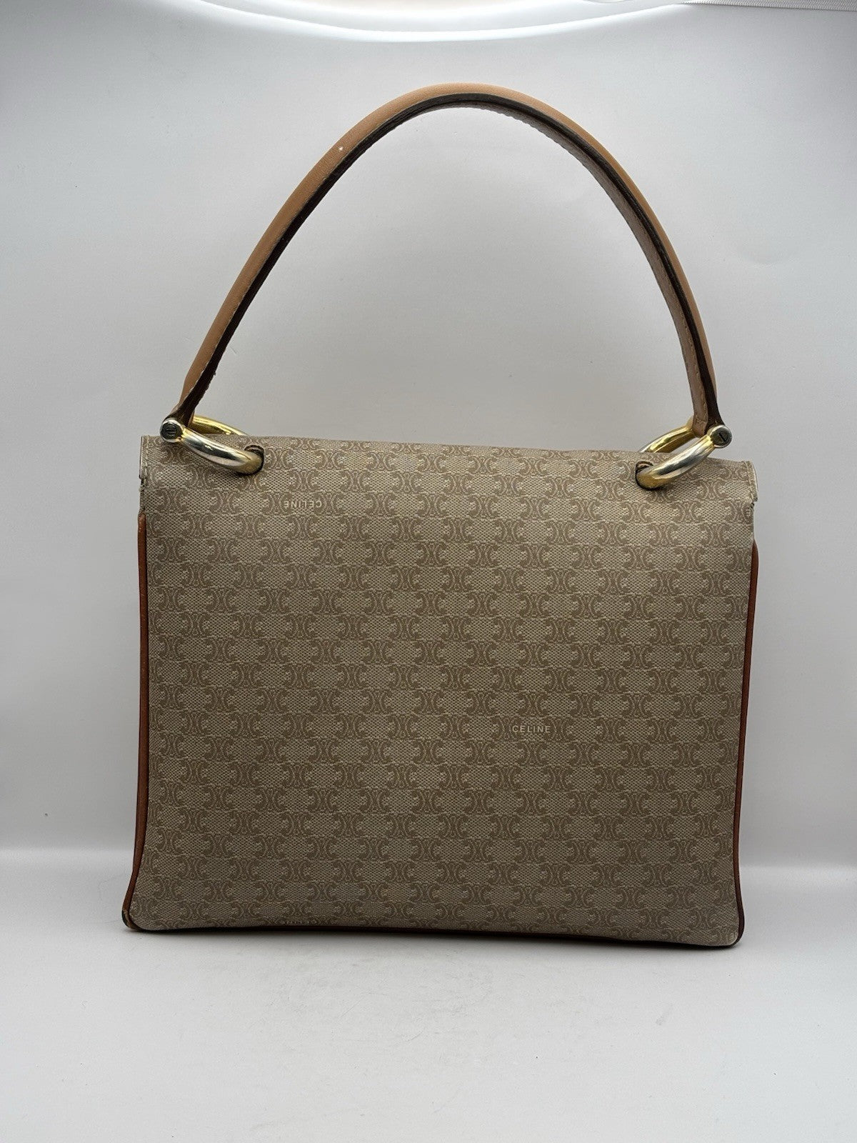 Celine Macadam leather top handle bag with a horse carriage logo buckle.