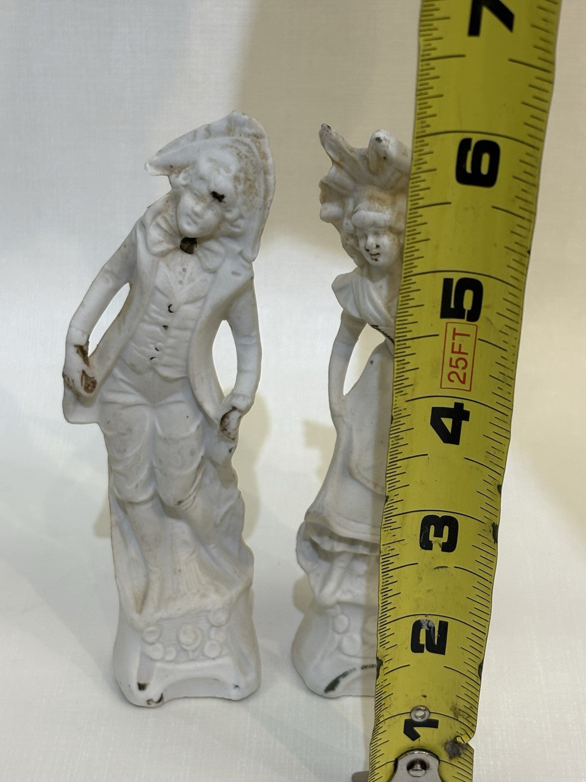 pair of vintage bisque porcelain figurines depicting a Victorian style couple