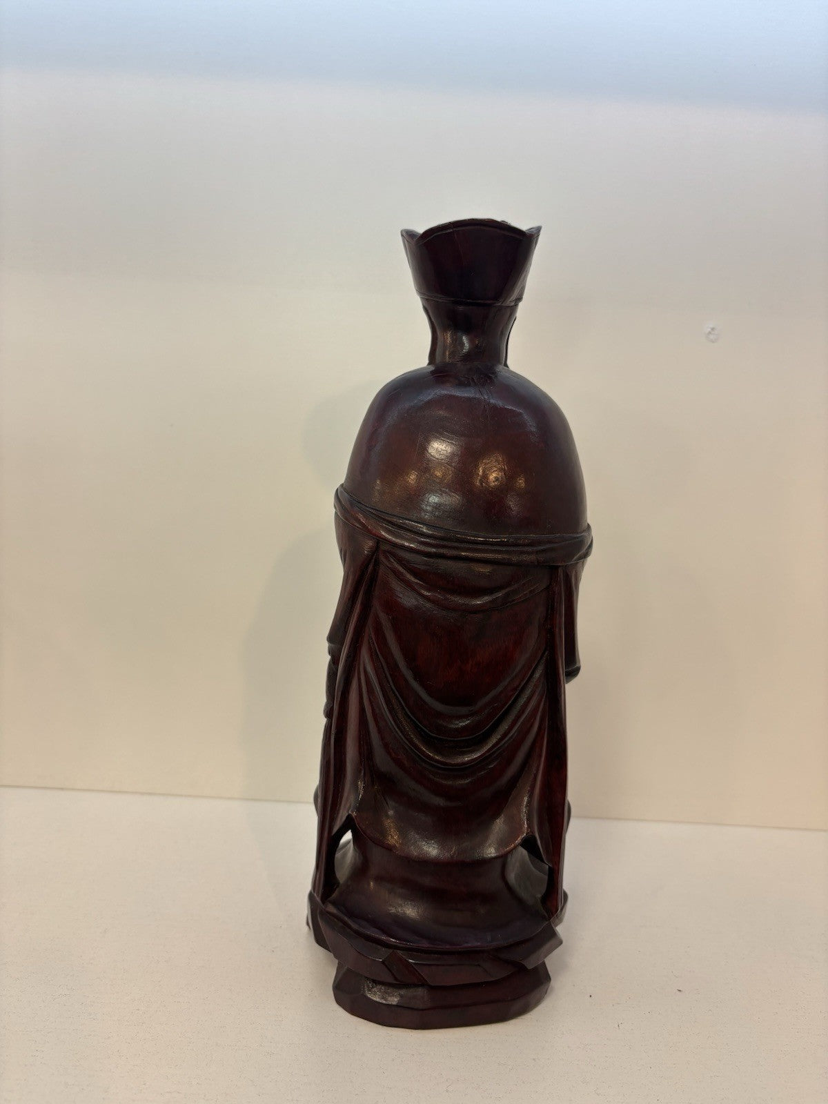 The statue is a carved wooden figurine of the Chinese deity Wenchang Wang.