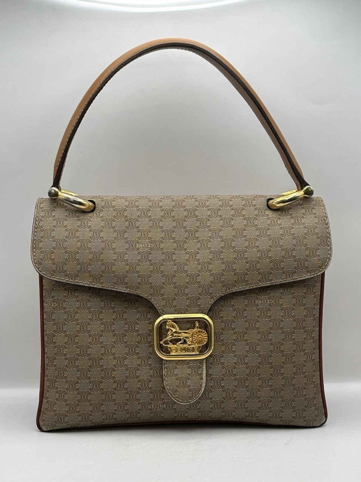 Celine Macadam leather top handle bag with a horse carriage logo buckle.