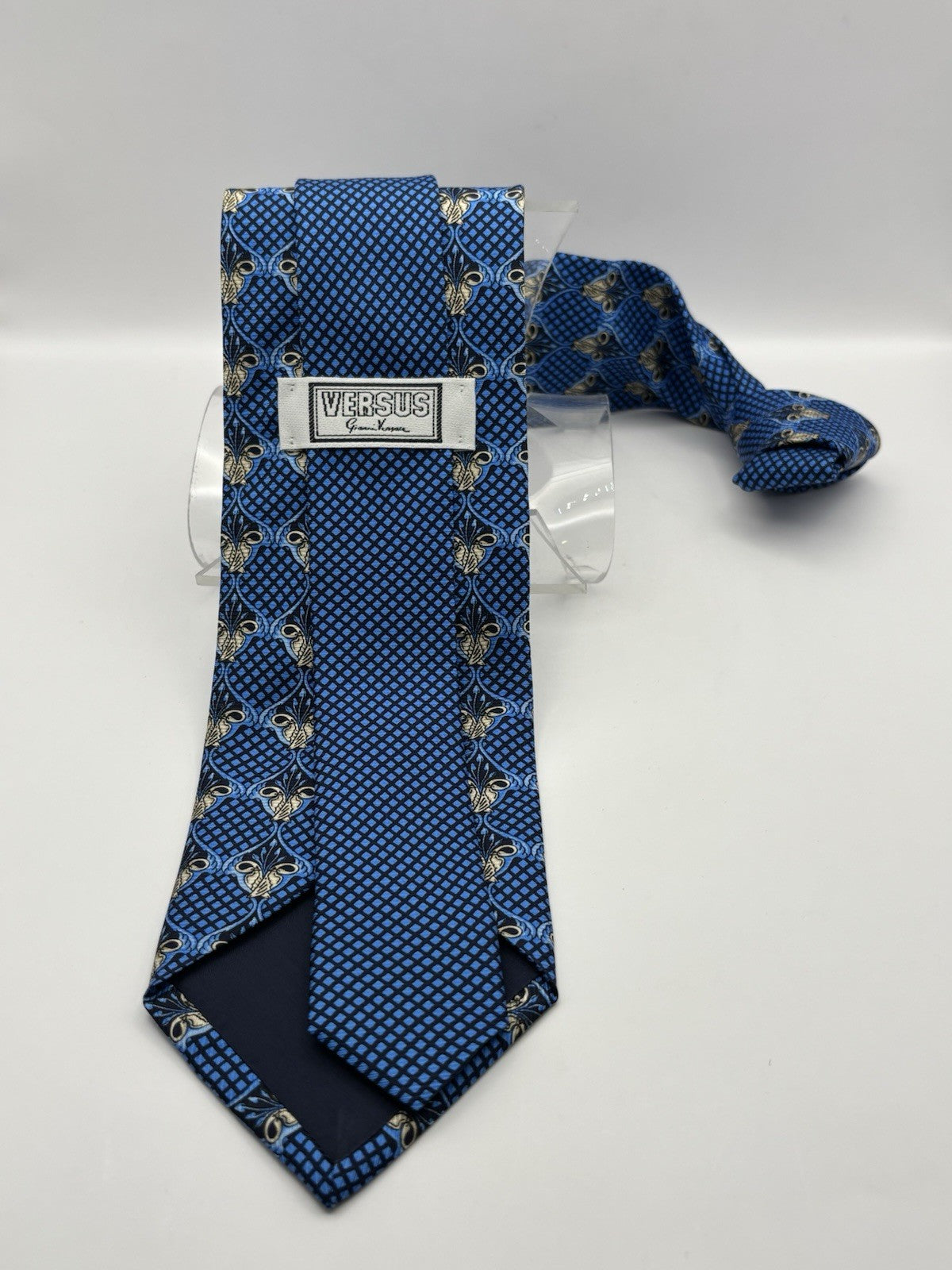 blue Versace necktie made In Italian silk and features a geometric pattern.