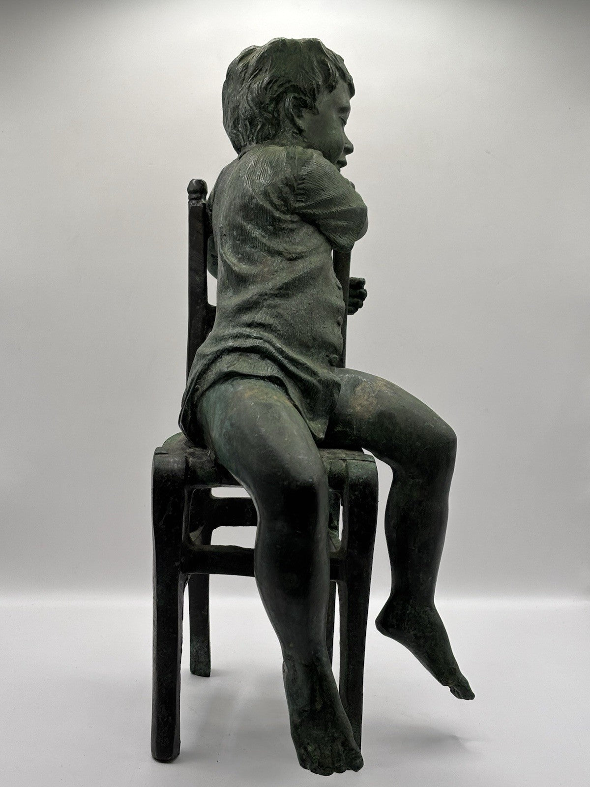 Maitland-Smith bronze boy in a chair, distinctive verde finish and brown patina.