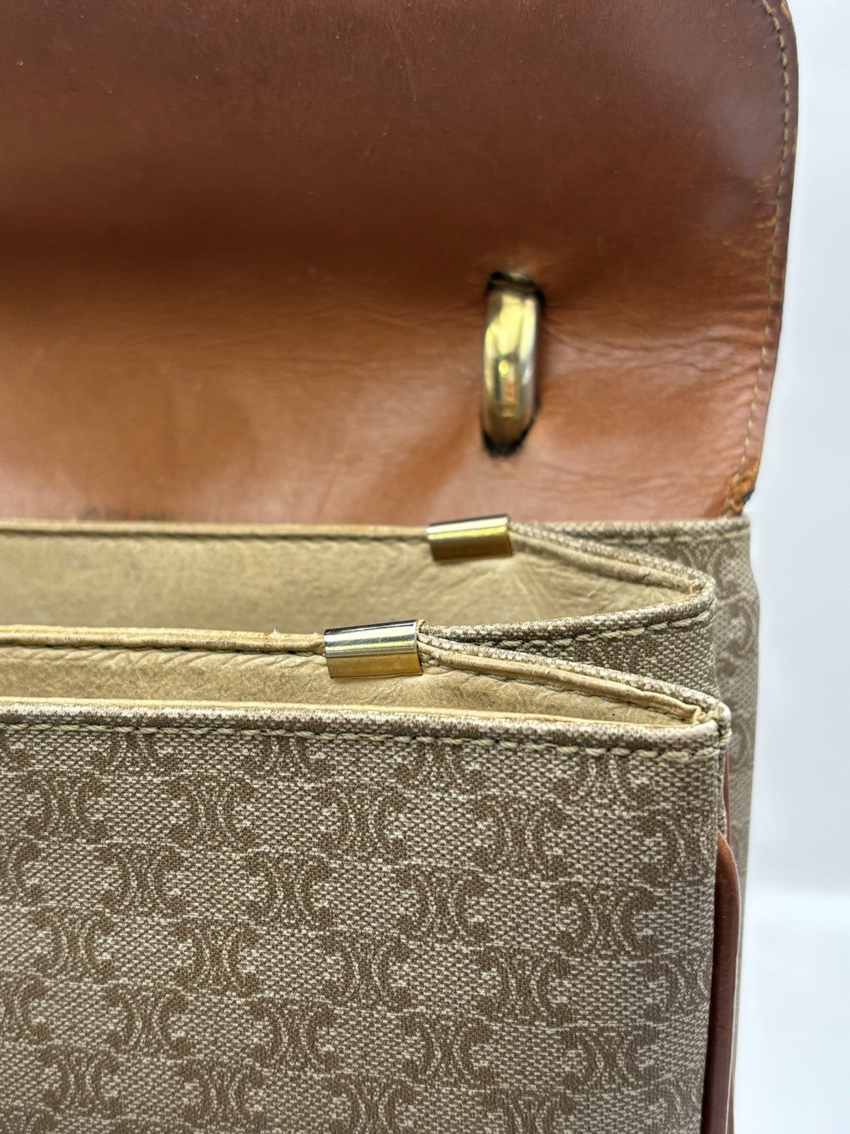 Celine Macadam leather top handle bag with a horse carriage logo buckle.