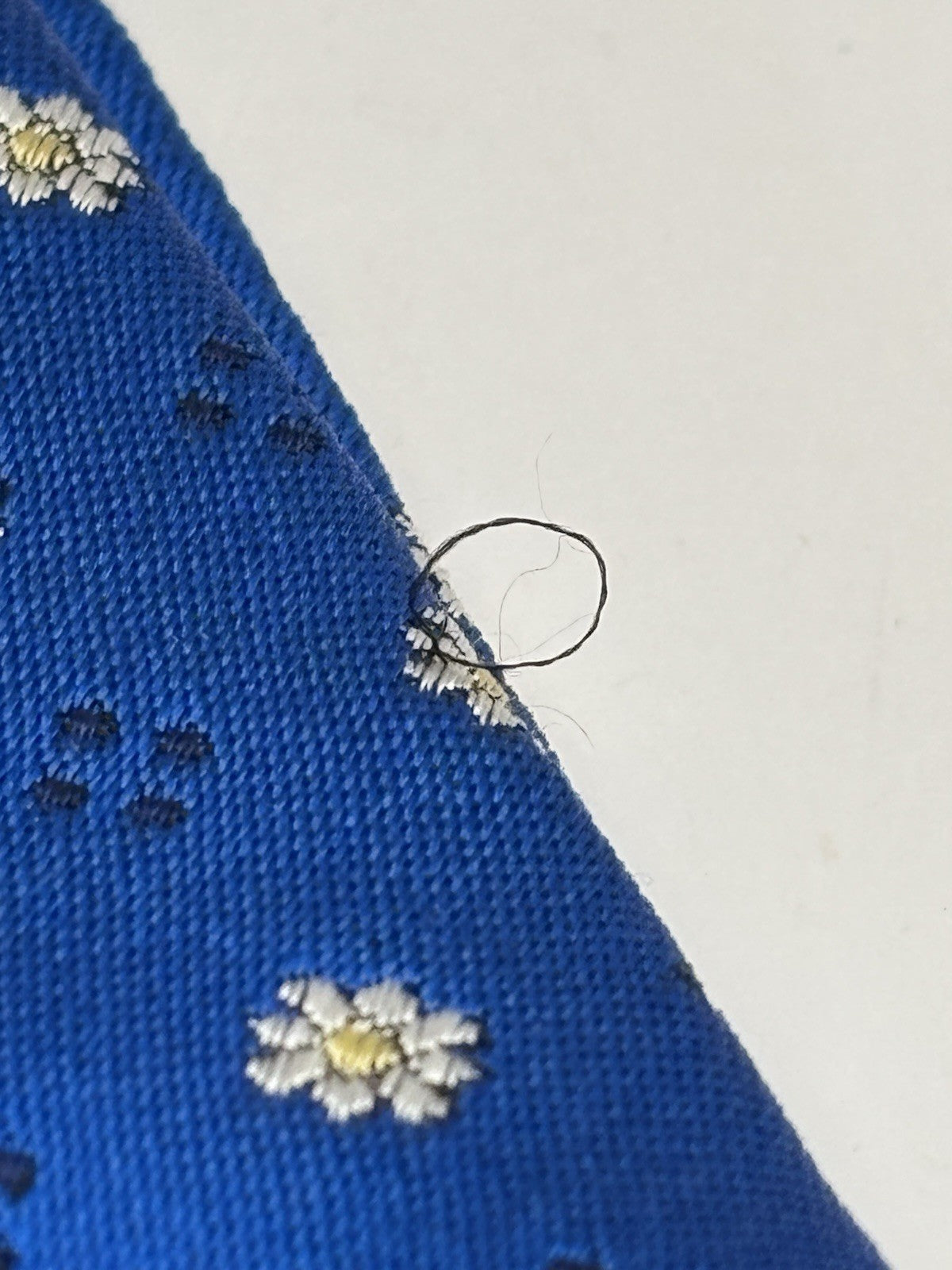 Versace tie vibrant blue silk Medusa head emblems and delicate floral patterns.